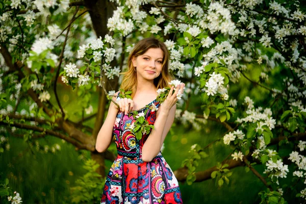 Beautiful woman in blooming garden — Stock Photo, Image