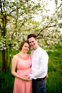 Çift çiçek açan dalları bahar günü altında aşık.