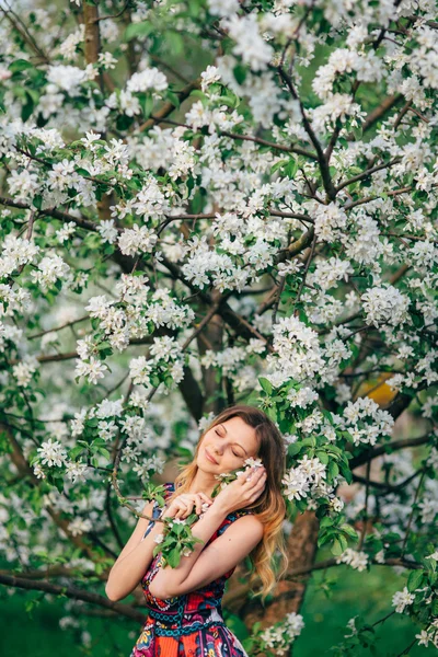 Mode vackra blonda kvinnan i blommande trädgård med äppelträd — Stockfoto