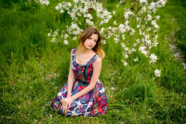 Módní krásná světlovlasá žena v kvetoucí zahradě z jabloní — Stock fotografie