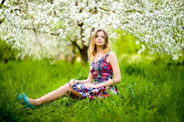 Beautiful woman in blooming garden — Stock Photo, Image