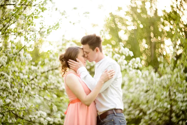 Pareja enamorada bajo ramas florecientes día de primavera . — Foto de Stock