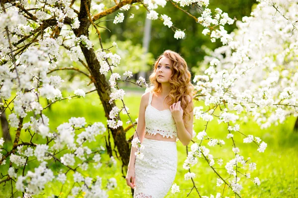 Sprężyna piękna dziewczyna, Blondynka, stojąc w kwitnący sad jabłkowy . — Zdjęcie stockowe