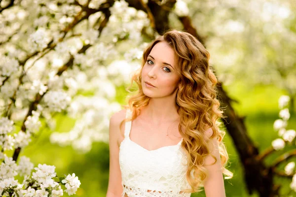 Mooie vrouw in de bloeiende tuin — Stockfoto