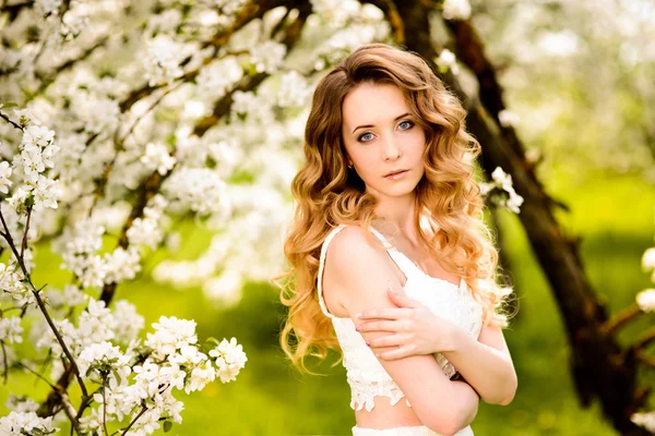 Mooie vrouw in de bloeiende tuin — Stockfoto