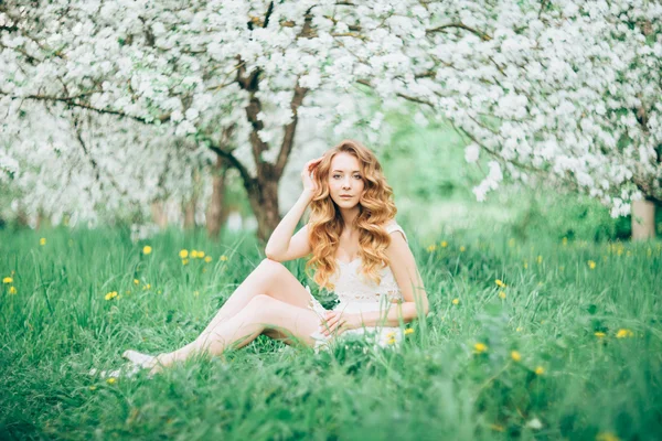 Çiçek açan bir elma meyve bahçesinde Bahar güzel kız ayakta, Sarışın, . — Stok fotoğraf