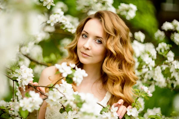 Chica hermosa primavera, rubia, de pie en un huerto de manzanas en flor  . — Foto de Stock