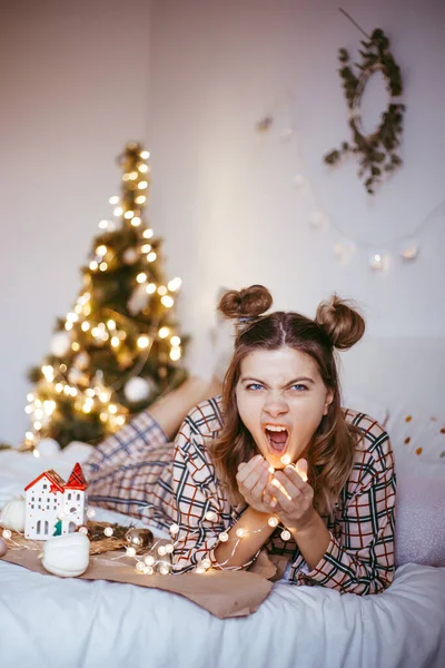 여성은 크리스마스 침실에서 아침에 일어나 웃으며 휴일을 집에서 보낸다 — 스톡 사진