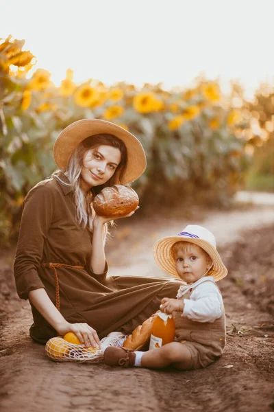 Jovem Bela Mãe Pequeno Filho Comem Pão Campo Girassóis Verão — Fotografia de Stock