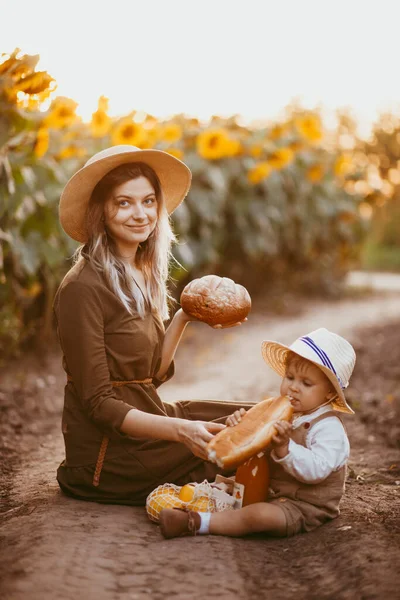 Jovem Bela Mãe Pequeno Filho Comem Pão Campo Girassóis Verão — Fotografia de Stock