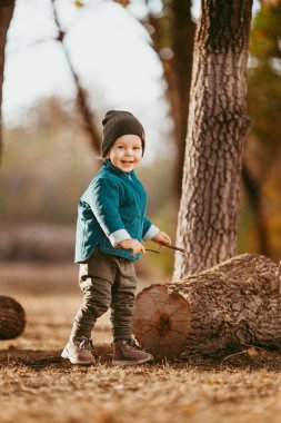 Neşeli çocuk koşuyor. Yeşil ceketli ve kahverengi pantolonlu bir çocuk. Seçici odaklı resim.