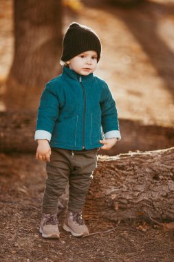 Mutlu çocuk geliyor. Yeşil ceketli ve kahverengi pantolonlu bir çocuk. Seçici odaklı resim.