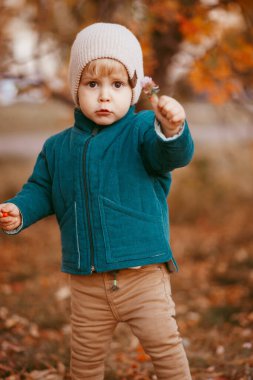 Mutlu çocuk geliyor. Yeşil ceketli ve kahverengi pantolonlu bir çocuk. Seçici odaklı resim.