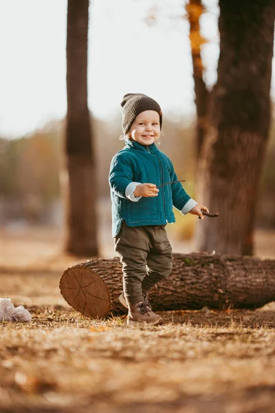 Neşeli çocuk koşuyor. Yeşil ceketli ve kahverengi pantolonlu bir çocuk. Seçici odaklı resim.