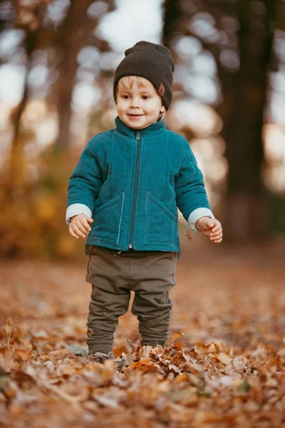 Viene el niño feliz. Un chico vestido con una chaqueta verde y pantalones marrones. — Foto de Stock