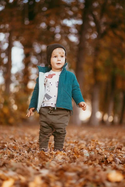 L'enfant heureux arrive. Un garçon vêtu d'une veste verte et d'un pantalon brun. — Photo