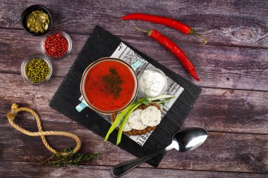 Bir tabakta geleneksel Ukrayna Rus çorbası. Koyu bir masada bir tabak kırmızı pancar çorbası. Pancar bahçesi manzaralı. Geleneksel Ukrayna mutfağı