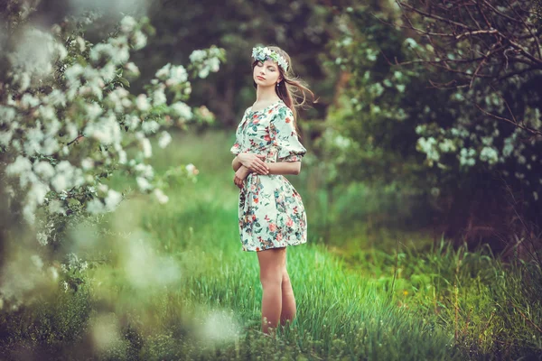 Güzel esmer kız çiçek açan bahçesinde — Stok fotoğraf