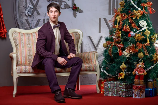 Retrato de un hermoso macho cerca del árbol de Navidad . —  Fotos de Stock