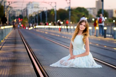 kadın bir köprüde günbatımında durumda.