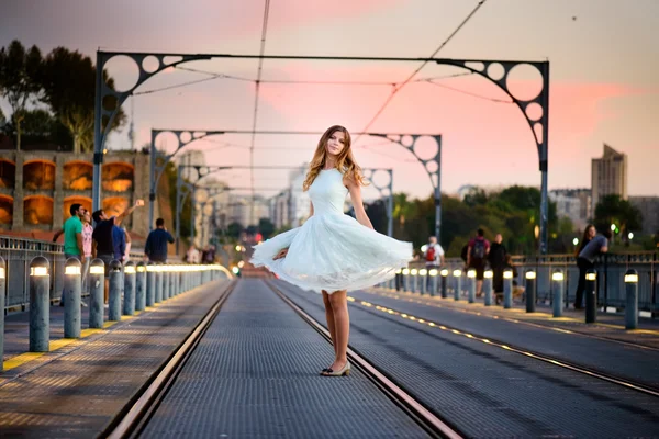 Женщина стоит на мосту на закате — стоковое фото