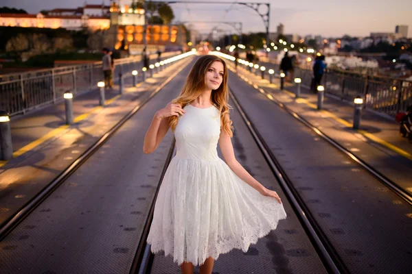 Donna si trova su un ponte al tramonto — Foto Stock