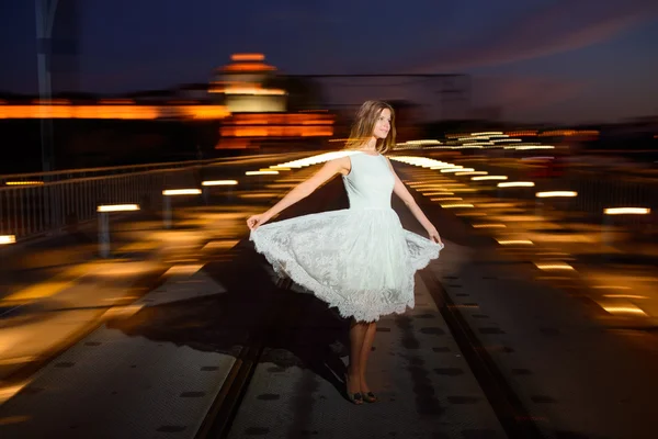 Mujer se para en un puente al atardecer — Foto de Stock