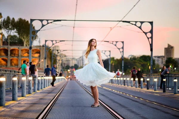 Женщина стоит на мосту на закате — стоковое фото