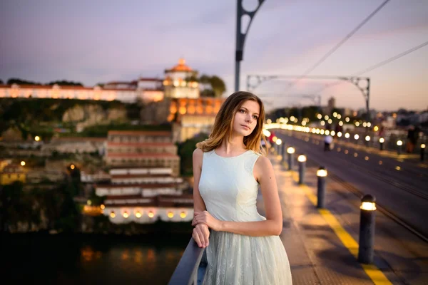 Donna si trova su un ponte al tramonto — Foto Stock