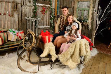 bir anne ve baba Noel kızak üzerinde oturan kız