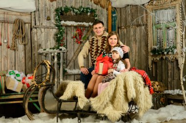 bir anne ve baba Noel kızak üzerinde oturan kız