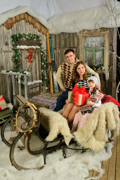 Menina com uma mãe e pai sentado no trenó de Natal — Fotografia de Stock