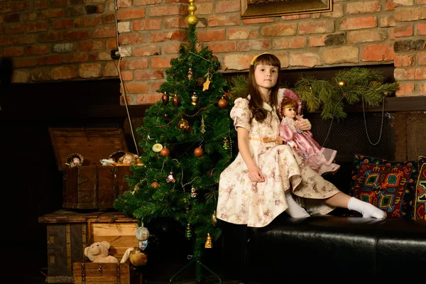 Noel ağacının yanında oturan küçük kız — Stok fotoğraf