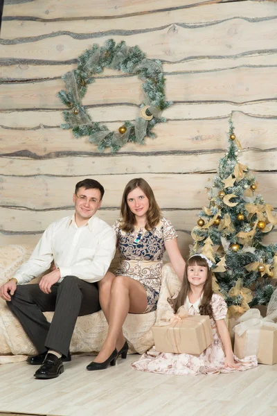 Family new year's eve around the Christmas tree — Stock Photo, Image