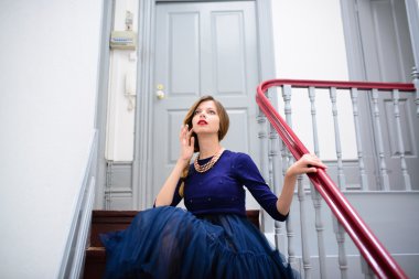 mavi elbiseli zarif kadın merdivenlerde teşkil etmektedir.