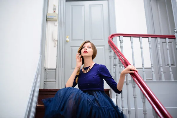 Elegante donna in abito blu posa sulle scale — Foto Stock