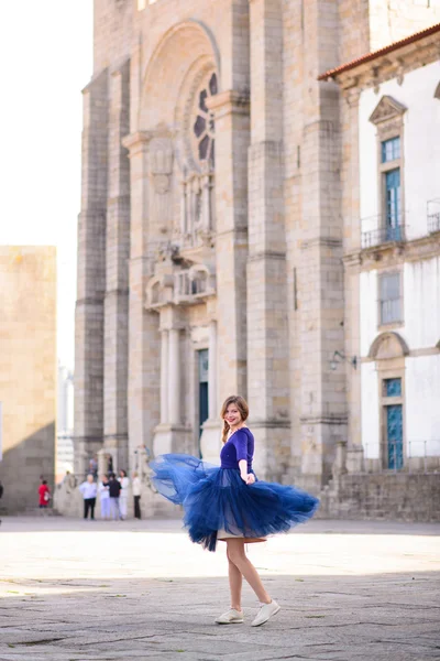 Jovem mulher elegante em azul vestido voador longo posando na escada contra o edifício da cidade velha — Fotografia de Stock