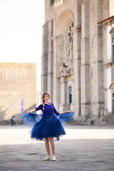 Young elegant woman in blue long flying dress posing at stairway against old city building — Stock Photo, Image