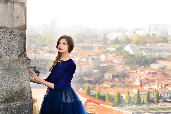 Young elegant woman in blue long flying dress posing at stairway against old city building — Stock Photo, Image