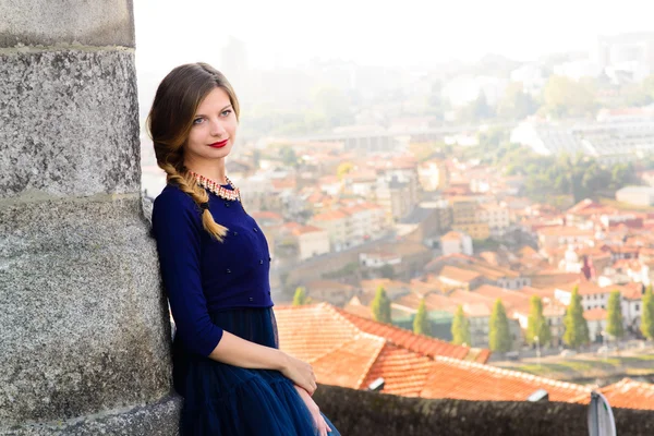 Молодая элегантная женщина в синем длинном летающем платье позирует на лестнице против старого здания города — стоковое фото