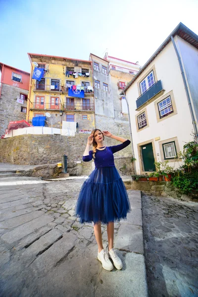 Mladá dívka stojí na ulici, obklopený barevnými domy v přístavu — Stock fotografie