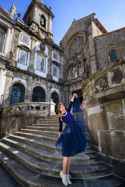 Дівчина позує в блакитній сукні, стоячи на кам'яних сходах — стокове фото