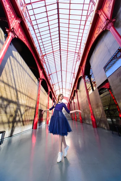 Elegant woman in blue long flying dress posing at stairway against old city building — Stock Photo, Image