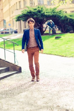 adam bej pantolon ve mavi bir ceket