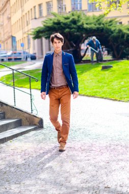 adam bej pantolon ve mavi bir ceket