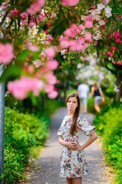 Giovane ragazza in piedi vicino albero con fiori — Foto Stock