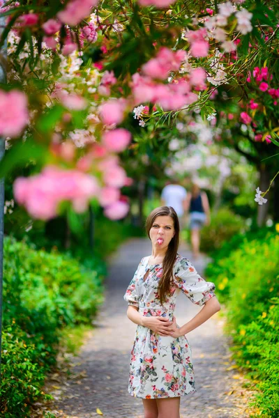 Giovane ragazza in piedi vicino albero con fiori — Foto Stock