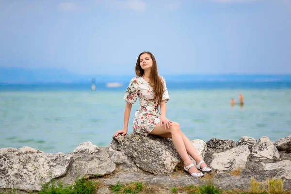 Mulher bonita sentada na rocha sobre o mar — Fotografia de Stock