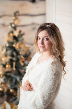 Güzel bir ağacın yanında oturan beyaz elbiseli güzel kız