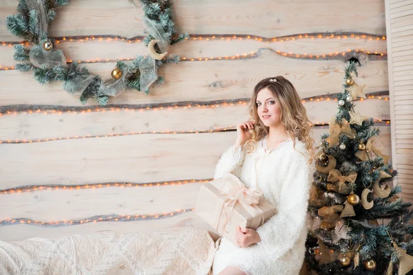 Fille près de l'arbre de Noël décoré dans un bel intérieur de lumière — Photo